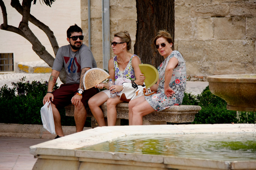 Los turistas se refugian en las sombras para evitar el intenso calor.