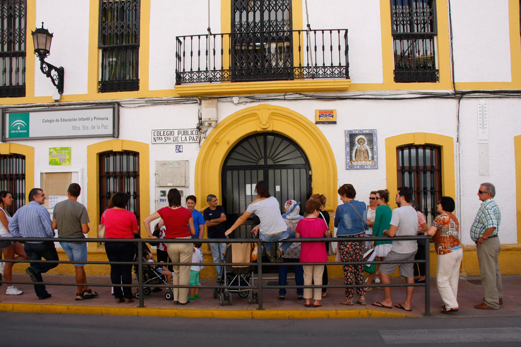 Un grupo de padres espera la salida de los pequeños a las puertas del colegio.