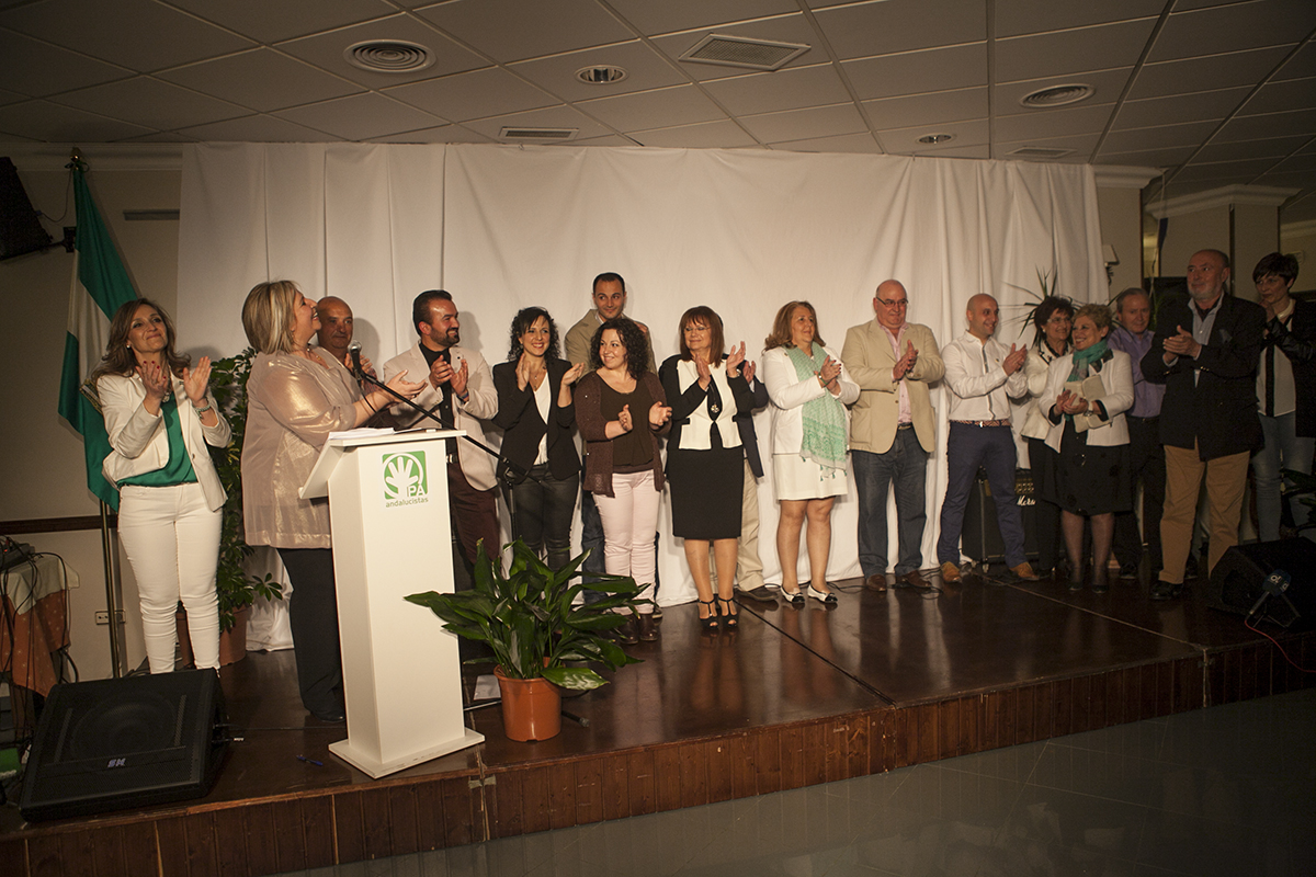 El Partido Andalucista (PA) ha celebrado hoy en el salón de actos del hotel Maestranza, que se quedó pequeño para acoger a los asistentes, el primer mitin de la precampaña electoral de las elecciones municipales que se celebrarán el próximo 24 de mayo. Los andalucistas, en un acto que contó con el mago Fran como conductor y con una versión roquera del himno de Andalucía, los andalucistas presentaron su candidatura y su compromiso electoral, que no programa electoral. Y es que, según anunció la candidata andalucista, Isabel Barriga, en esta ocasión no van a ofrecer un programa de gobierno a los rondeños, ya que "nuestro programa eres tú". De este modo Isabel Barriga anunciaba que si obtienen el gobierno de la ciudad serán los rondeños los que elaboren el programa anual de gobierno en reuniones por sectores de las que saldrán una serie de propuestas que serán llevadas a un debate en el teatro para firmar con compromiso anual para su realización. Además, la candidata andalucista explicó que sus concejales se comprometerán a contar en la web municipal cada una de las acciones que realicen en referencia a cada una de las propuestas que salgan del encuentro con los rondeños. Barriga también se comprometió a acoger a todos aquellos inversores que lleguen a la ciudad y eliminar todos los obstáculos que se puedan producir para su implantación, ya que, según afirmó "la ley es una, pero no saben ustedes las de vueltas que se le pueden dar". Eso sí, se mostró partidaria de aprovechar los recursos locales para el desarrollo de la comarca. En este sentido, insistió en la necesidad de ser cabecera de comarca, algo que aseguró que se había logrado ya con el desarrollo de proyectos como Ronda Romántica. Por otra parte, también resaltó la necesidad de convertir Ronda en una ciudad "innovadora". No obstante, Isabel Barriga se mostró partidaria de que sean los problemas más inmediatos y básicos de los rondeños los que se aborden. "¿Cómo vamos hablar de autovías si hay un rondeño que no puede pagar la luz?", señaló Barriga. La candidata andalucista también tuvo un recuerdo para sus compañeros que ya no están: José María Ortega de la Cruz, Vicente Becerra y Manuel Cañestro. De igual modo, agradeció a los concejales Ángel Vázquez y Francisco Barea, que no repetirá en la candidatura, el trabajo realizado en este tiempo. El mitin también contó con la presencia e intervención del secretario andaluz del PA, Antonio Ruiz, que fue el encargado de atacar a sus socios de gobierno del PP y al PSOE. Los populares fueron su primer objetivo de crítica, acusando a la candidata del PP, aunque no la nombró directamente, de haberse pasado por el "arco" la ley electoral con la colocación de vallas, algo que los populares hicieron la pasada semana. "Hoy aquí está la que será alcaldesa de Ronda, no le quepa ninguna duda, por mucho que alguno y alguna pongan vallas en tiempos que no le corresponden, la ley se la pasan por el arco", dijo Ruiz. "Algunos parece que son funcionarios, más que concejales, ejercen las 24 horas del día, los fines de semana, en todo momento, es la diferencia entre los concejales andalucistas y los concejales de nuestros socios", afirmó Ruiz. Las críticas también apuntaron al PSOE, calificando de "desfachatez" la situación que presenta el nuevo hospital comarcal, mientras reprochaba a los populares que sus compañeros en Málaga y Madrid no hubiesen apostado por Ronda y se hubiese invertido más en otros municipios.