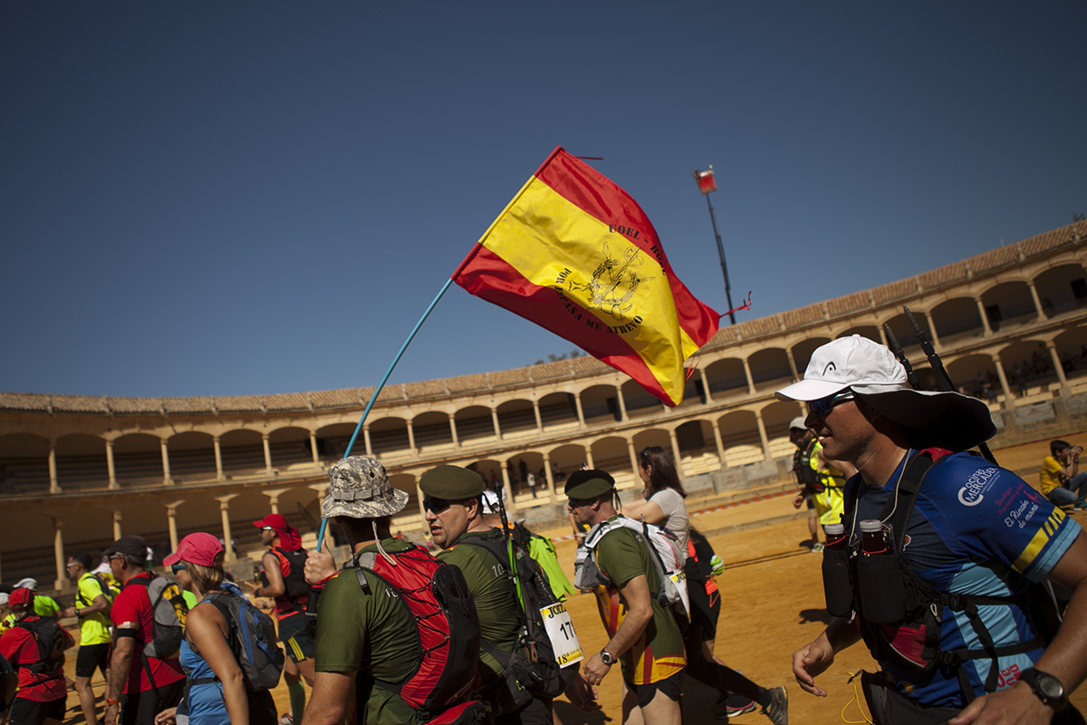 Un grupo de deportistas cruzando el ruedo de la plaza de toros de Ronda.
