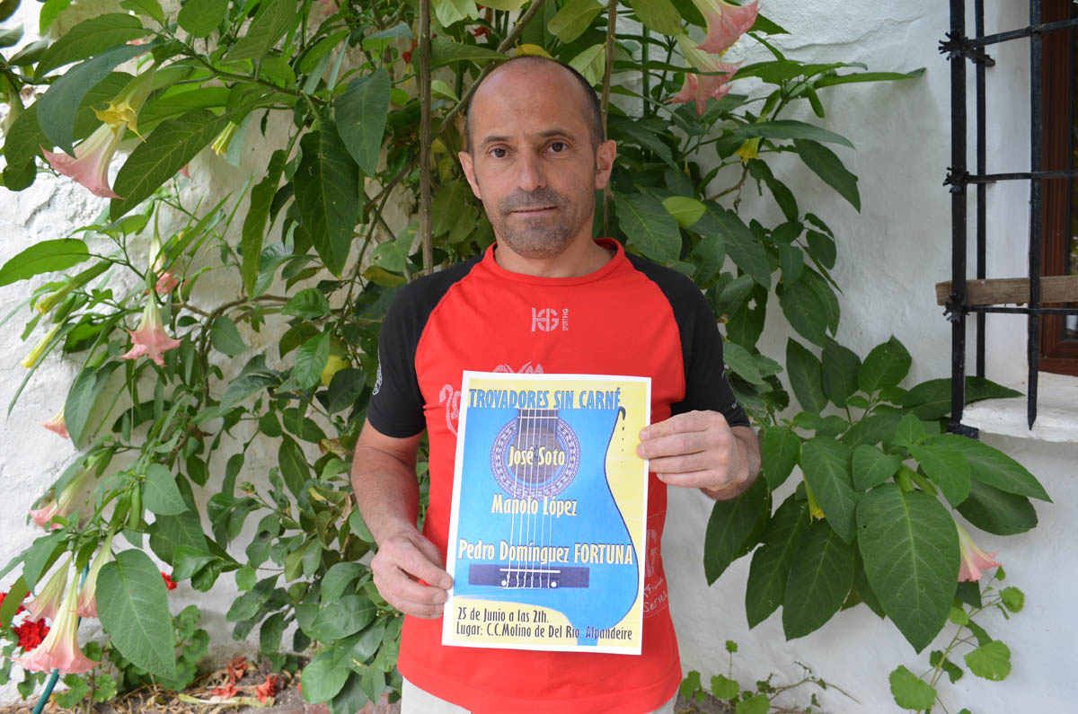 El organizador del concierto muestra el cartel.