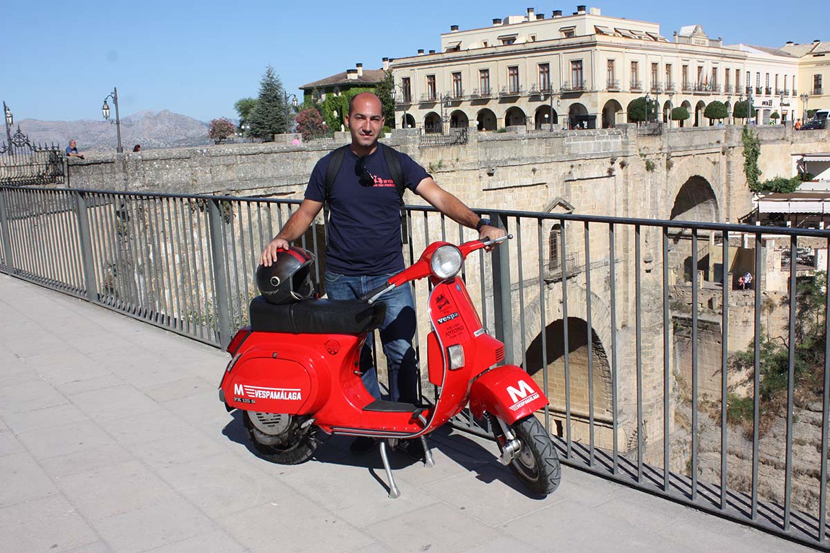 El motero malagueño con su Vespa en el Puente Nuevo de Ronda.