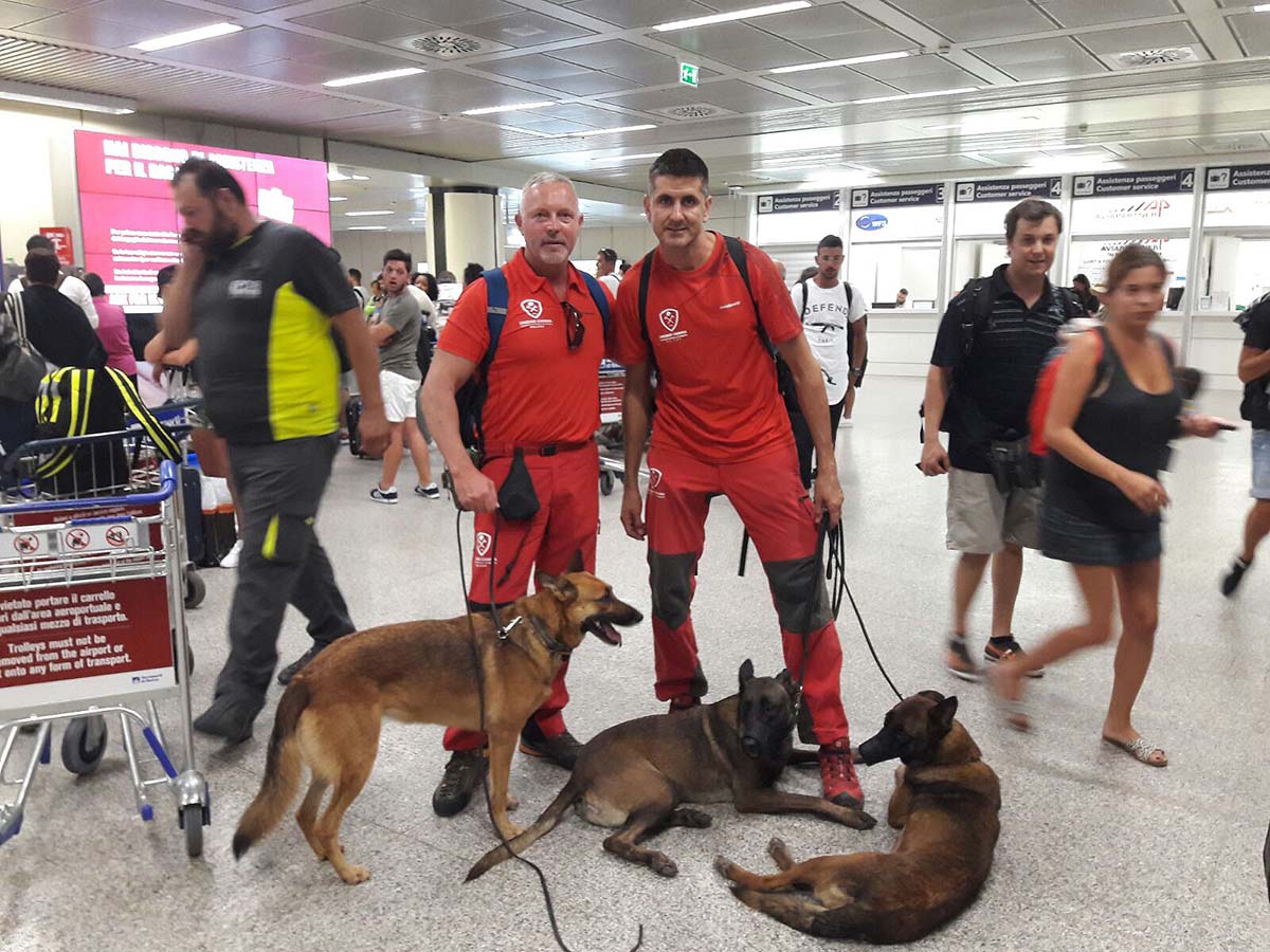 Los dos bomberos y los perros en el aeropuerto de Roma.