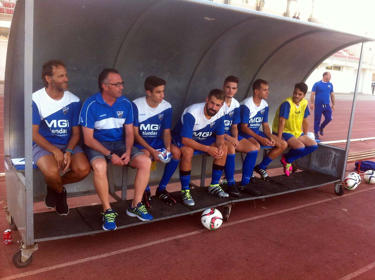 El entrenador junto a jugadores del Ronda en el banquillo.