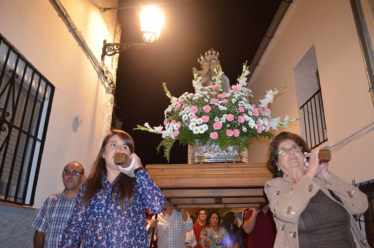 Las mujeres del pueblo portando a la imagen de la Patrona.