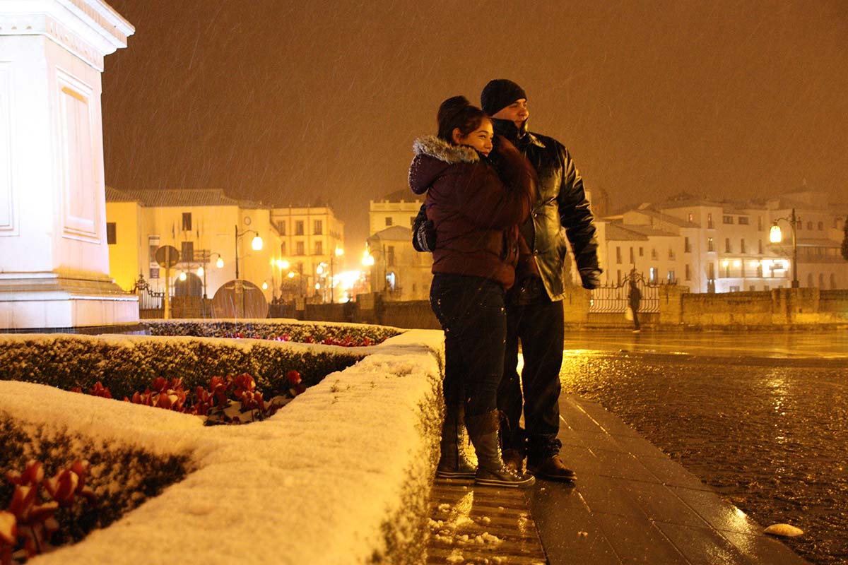 Una pareja de turistas contempla una nevada en la plaza de España.