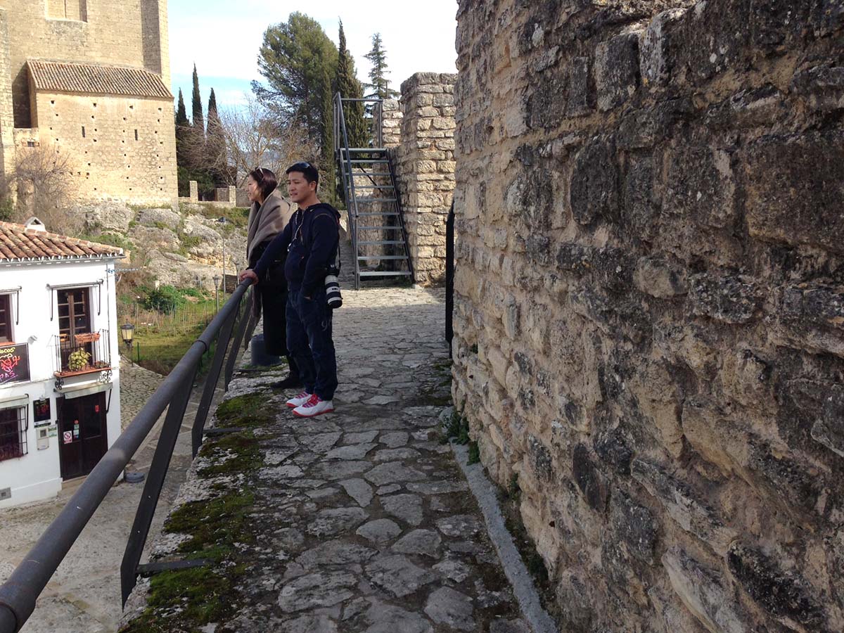 Dos turistas se apoyan en la baranda que carece tirantas de seguridad.