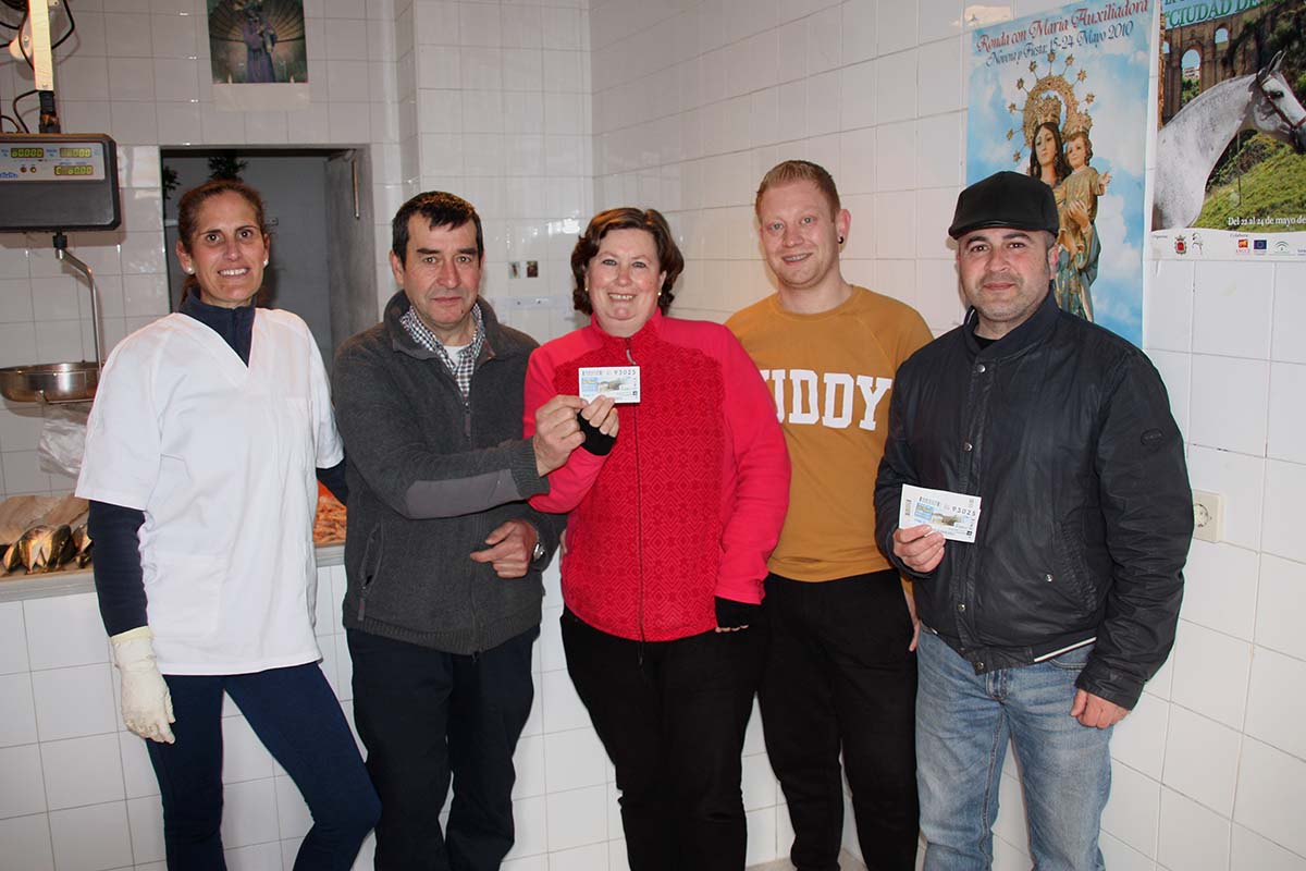 Afortunados celebran en la pescadería de la barriada el premio de la ONCE.