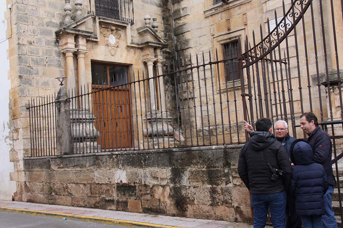 El sacristán explica a periodistas y vecinos por dónde entraron los ladrones.