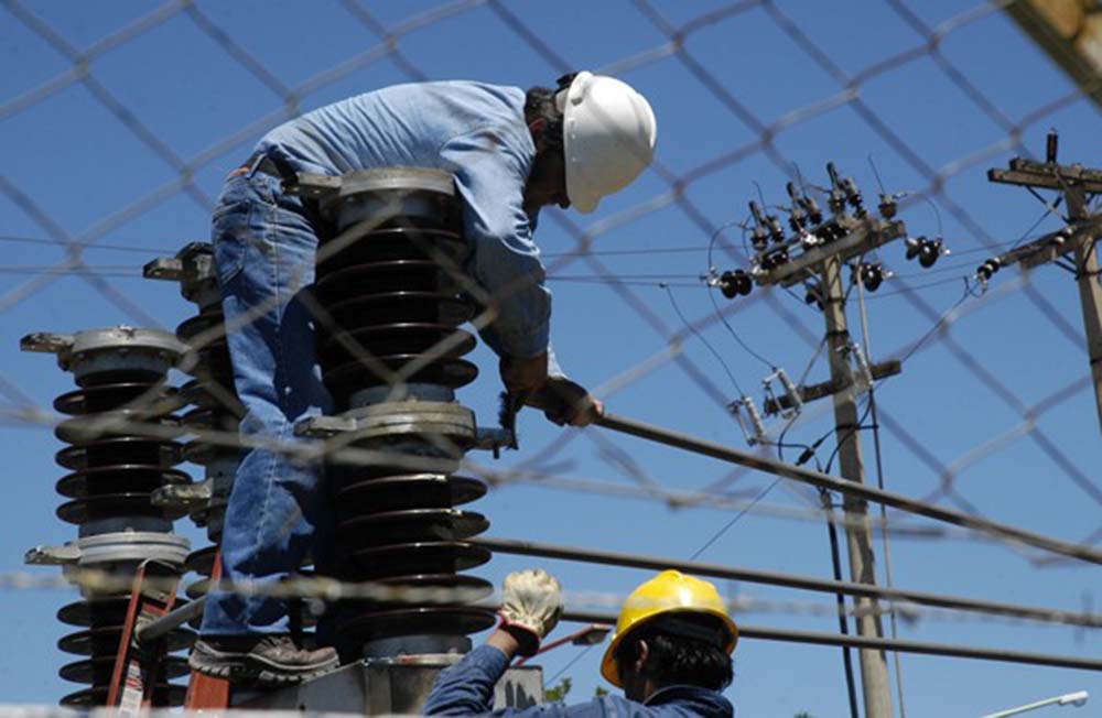 Unos operarios realizan mejoras en un tendido eléctrico.