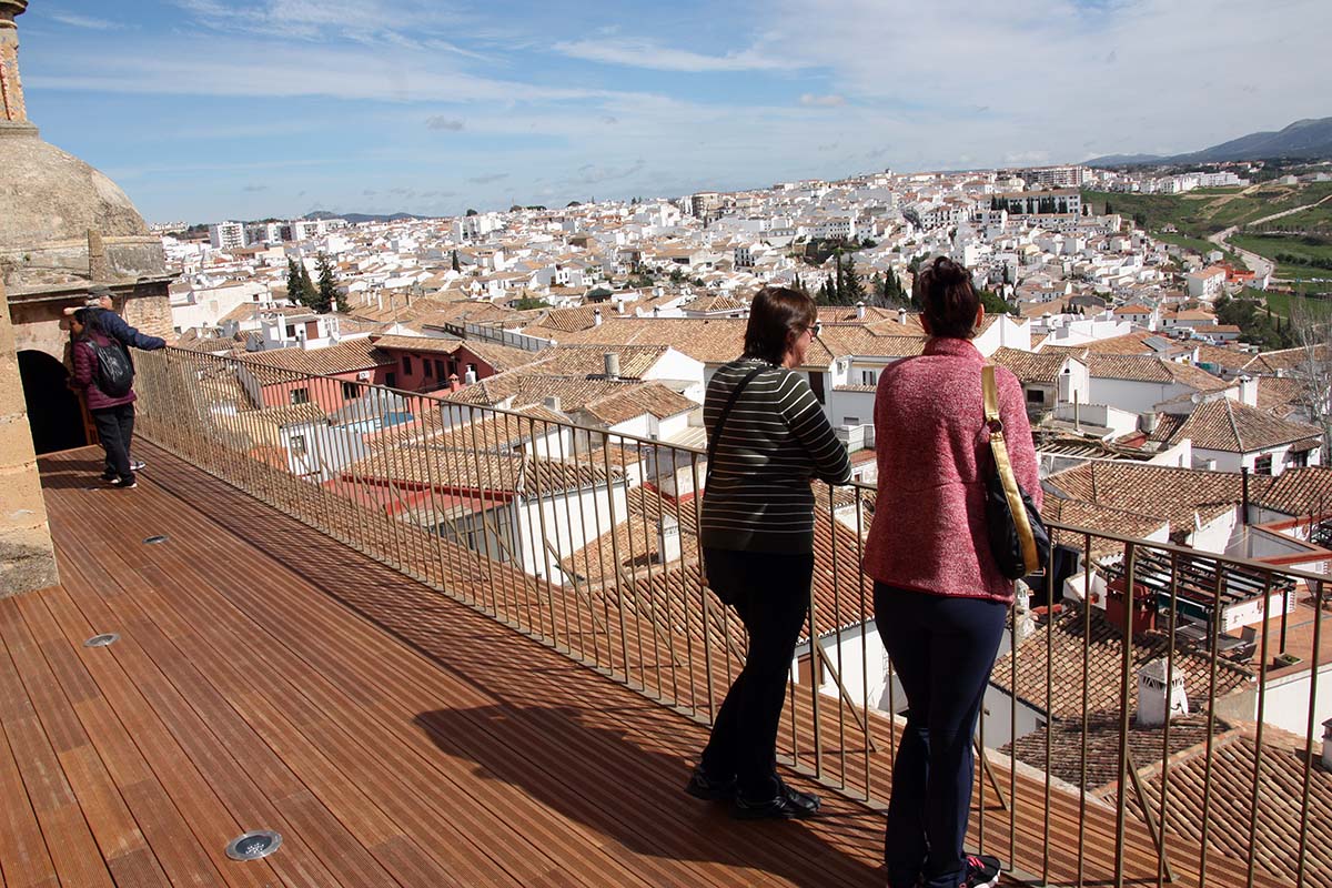 Dos turistas observando la ciudad de Ronda desde la pasarela de Santa María la Mayor.