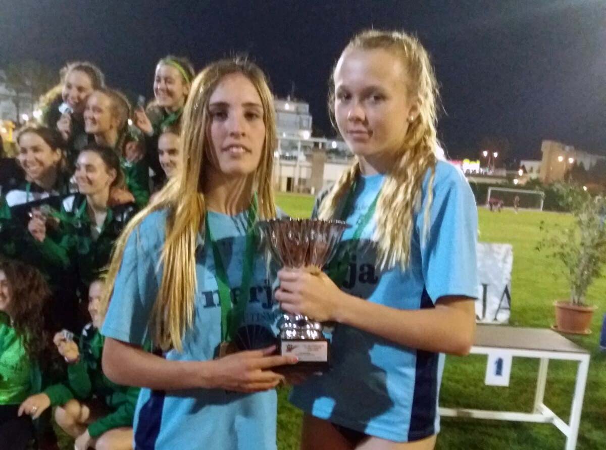 Las dos jóvenes corredoras muestran la copa obtenida.