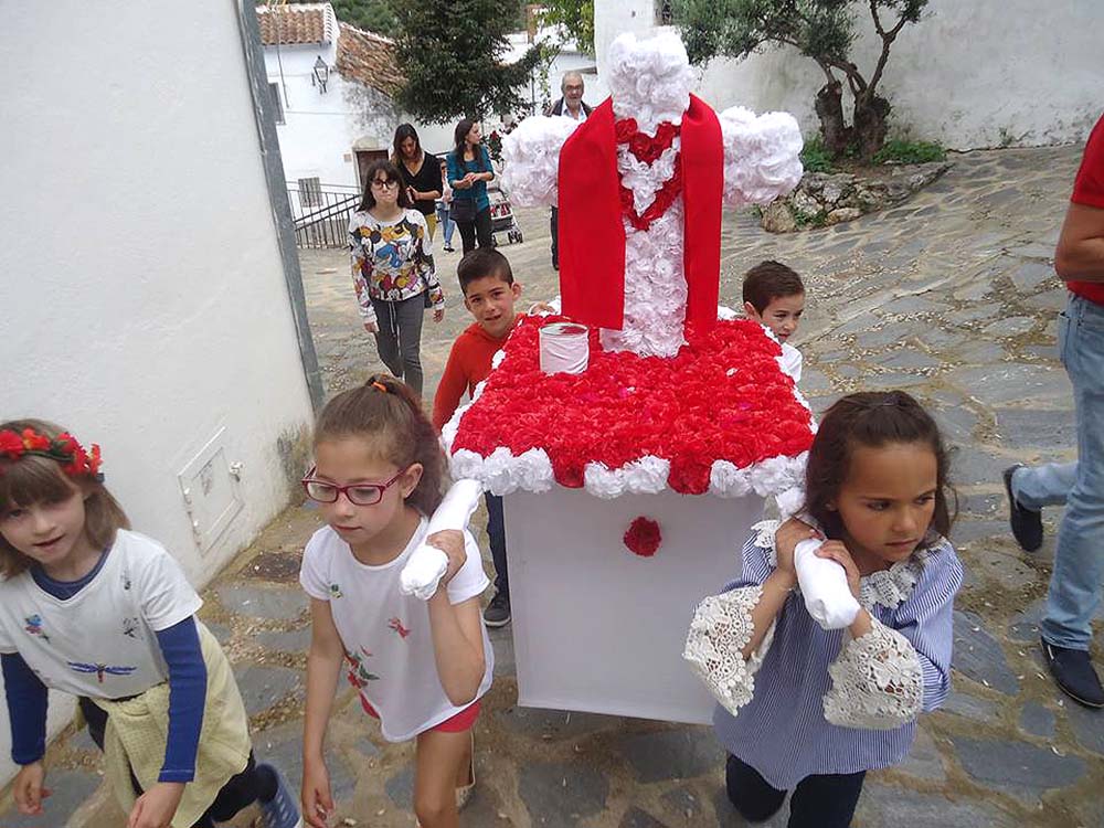 Niños de Parauta portan el trono con la cruz.