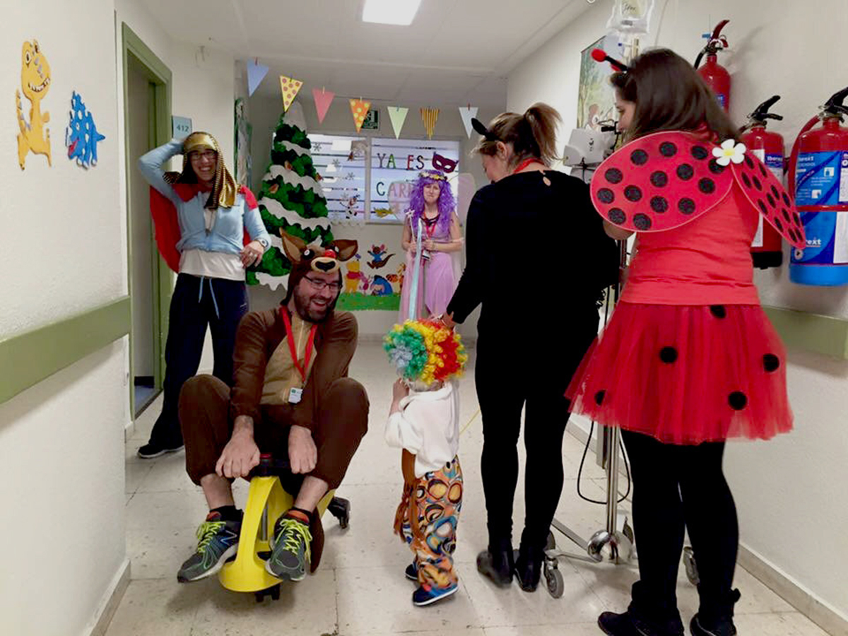 Voluntarios de Avoi animando a un niño ingresado en un hospital.