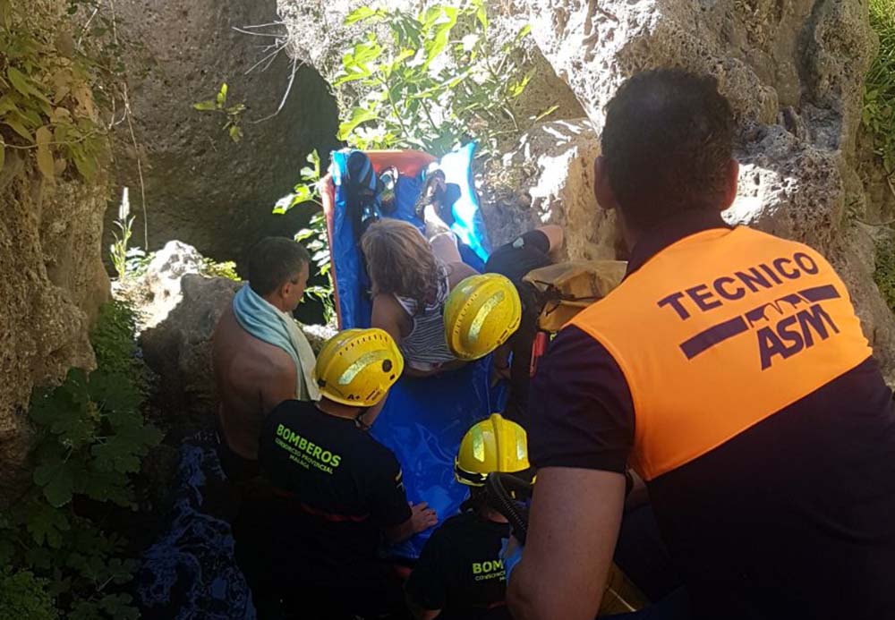 Momento en el que la turista es rescatada por los efectivos en el cauce del río Guadalevín.