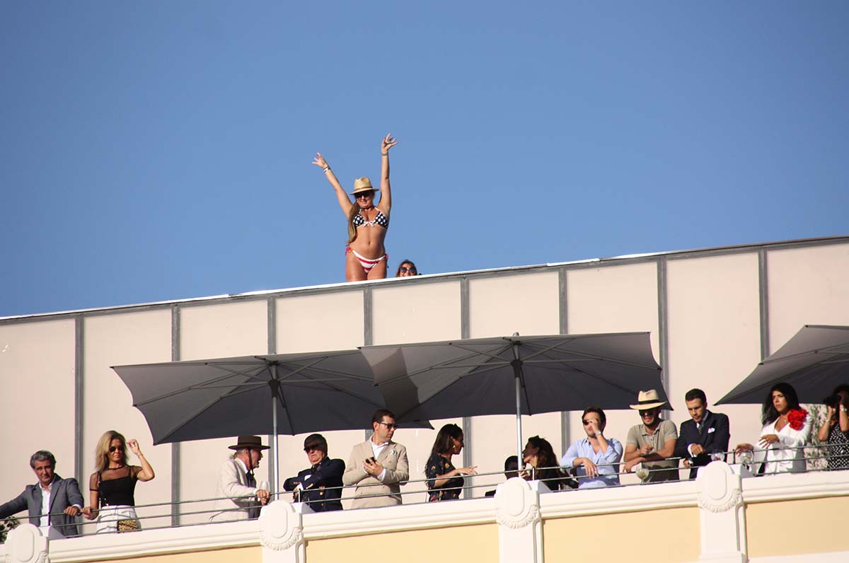 Una turista saluda en bikini desde la terraza del nuevo Hotel Catalonia durante los toros.