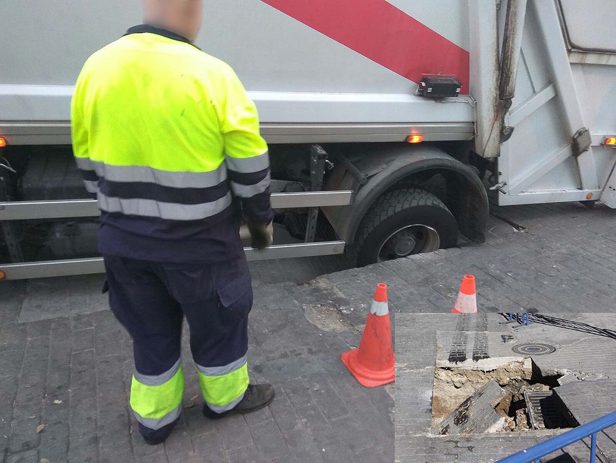 Una de las ruedas traseras ha quedado atrapada en el socavón que se jha producido. Foto José Antonio Sánchez.