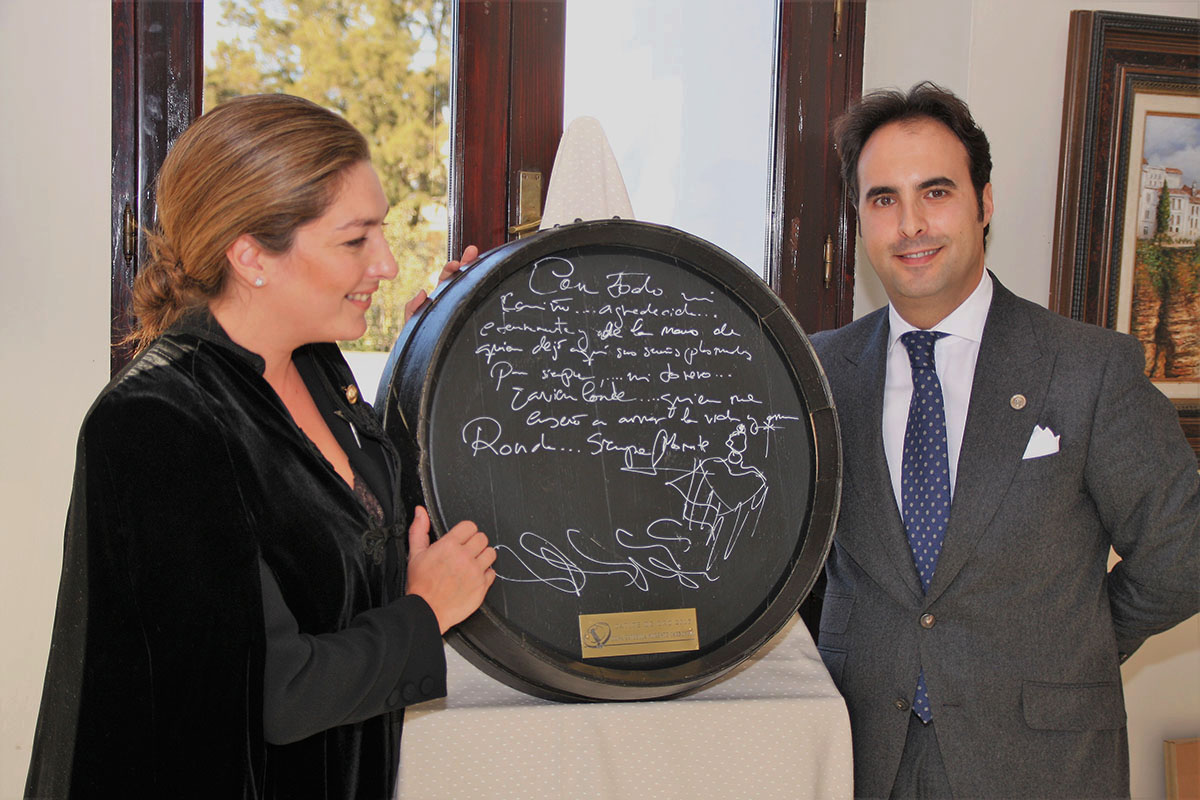 La cantante junto al presidente de la Peña El Catite estampando su firma en un barril.