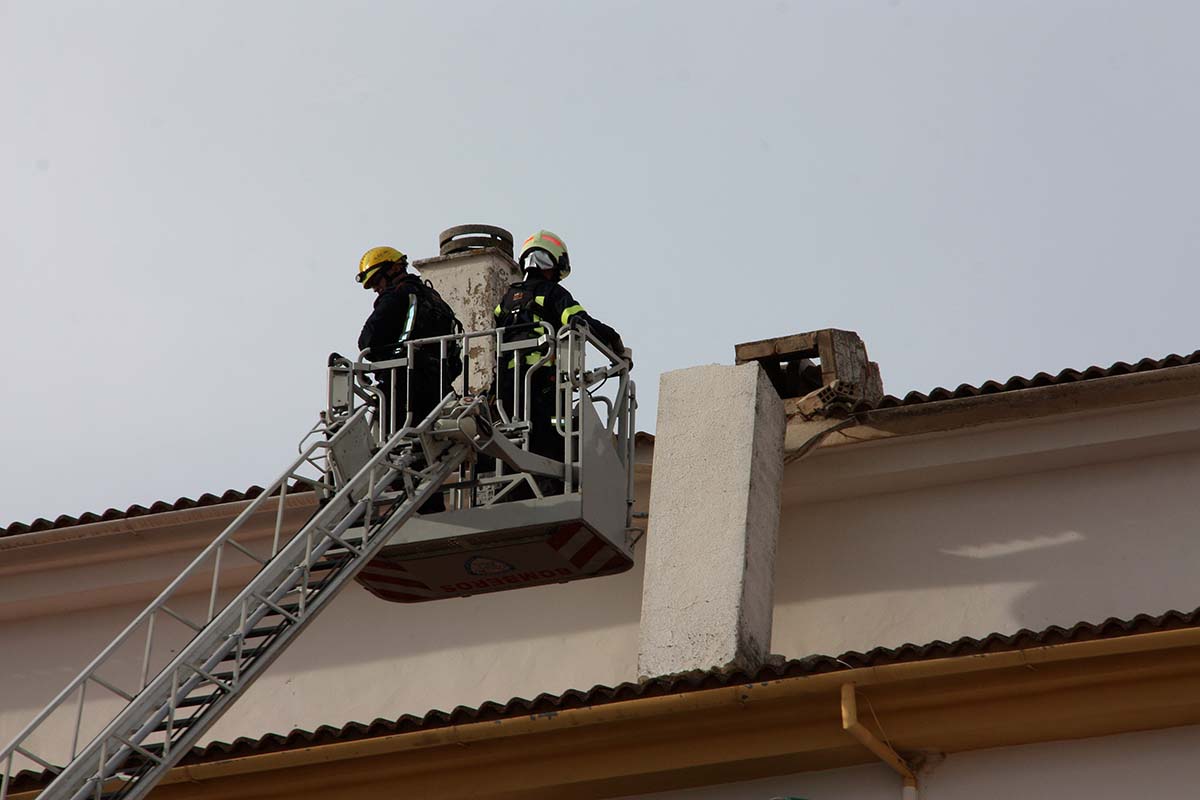 Los bomberos actúan en una chimenea desprendida en un bloque de la barriada de San Rafael.