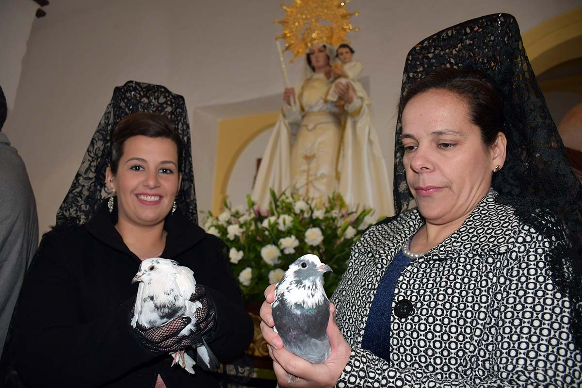 Dos vecinas de Algatocín con dos palomas en sus manos antes de soltarlas.