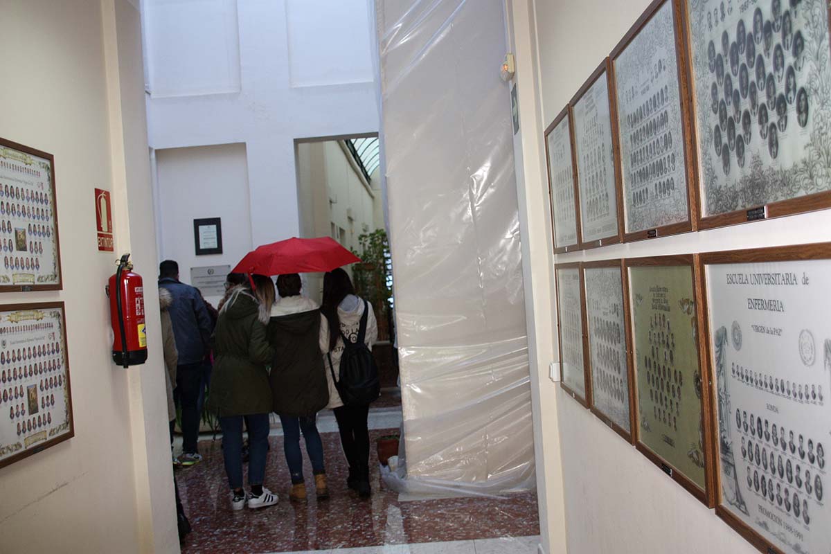 Estudiantes se resguardan de la lluvia con paraguas en los pasillos de la Escuela Universitaria de Enfermería.