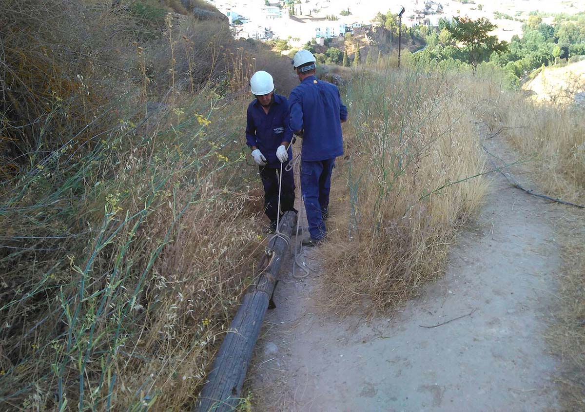 Dos operarios de una empresa eléctrica trabajando junto a Las Murallas de Ronda.