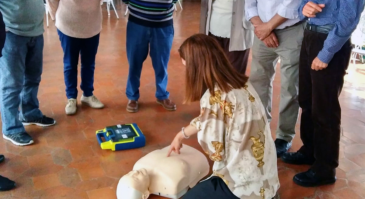 Una profesional explica a las personas mayores las técnicas de reanimación.