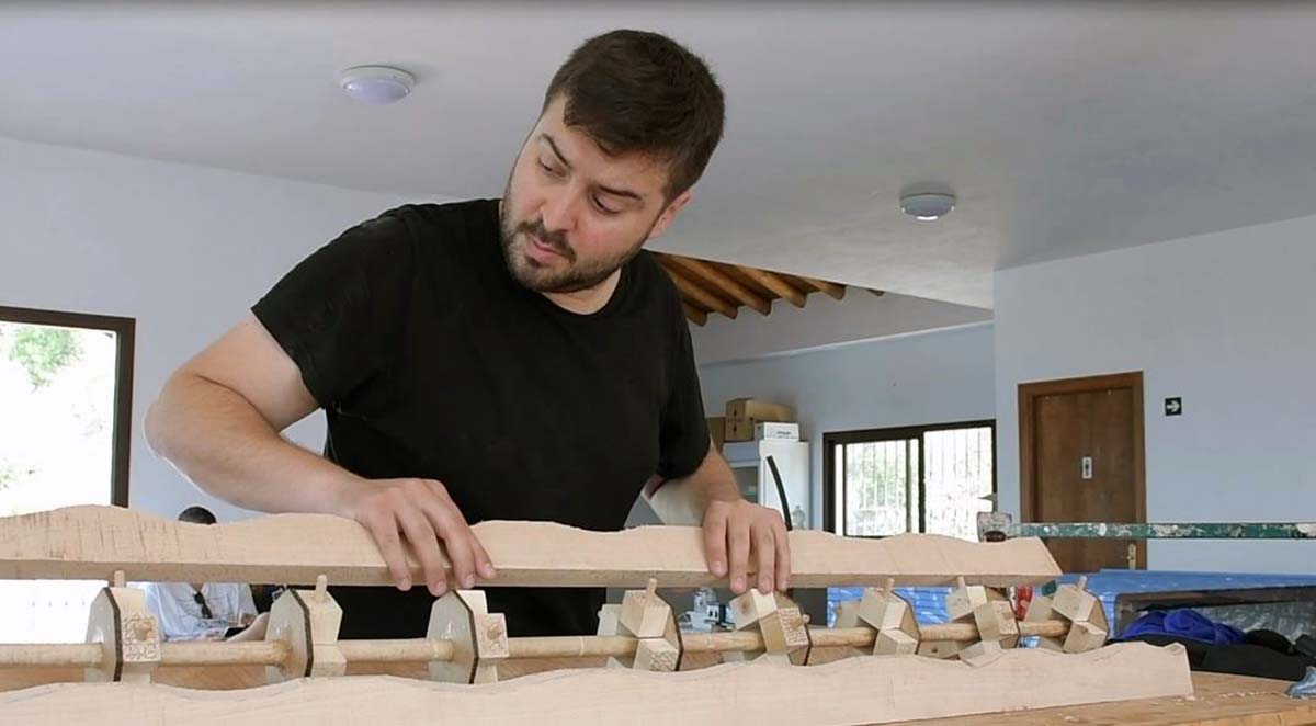 Uno de los artistas elabora una pieza de madera en uno de los talleres.
