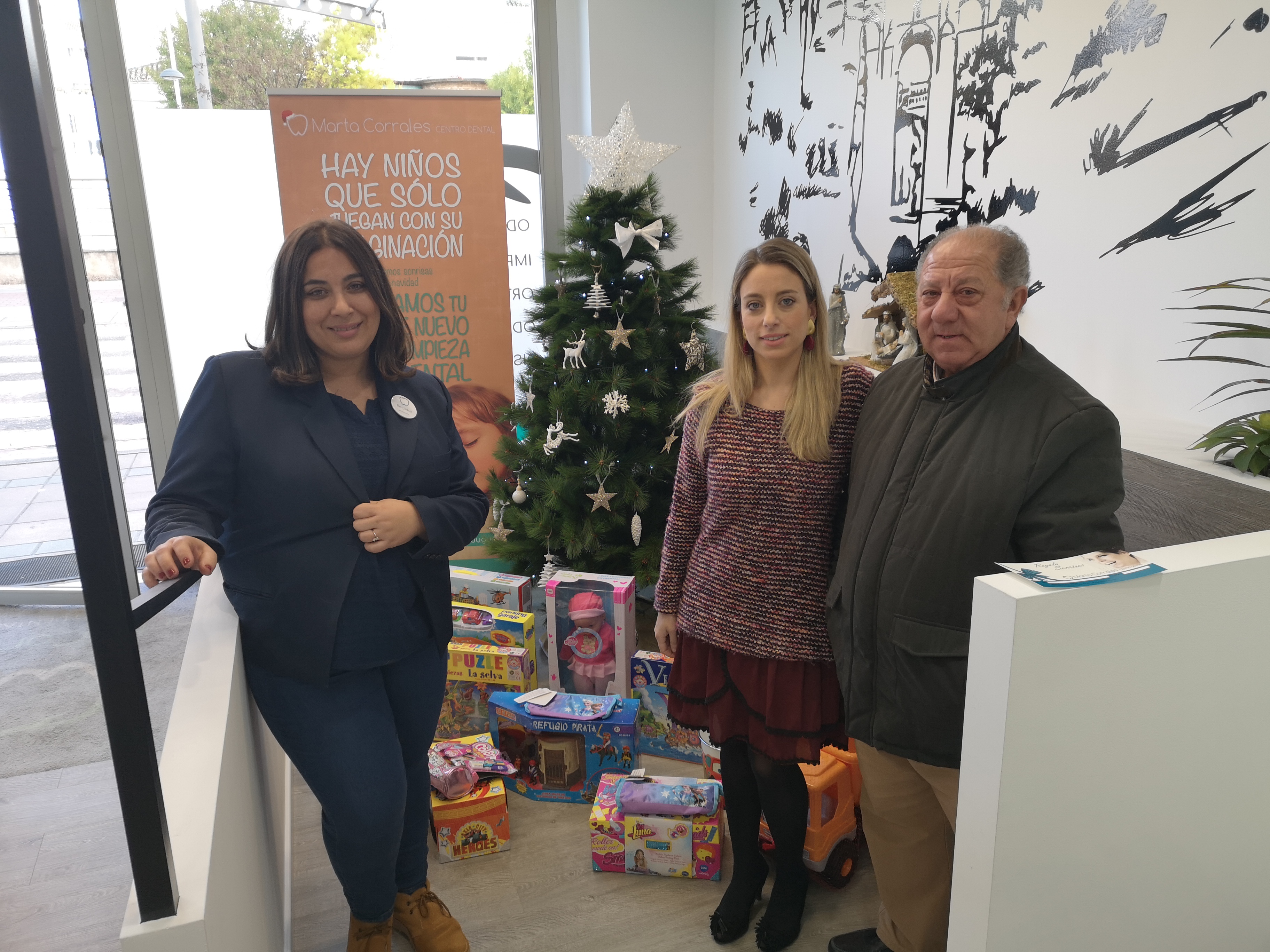 Los juguetes se están depositando bajo un árbol de Navidad.
