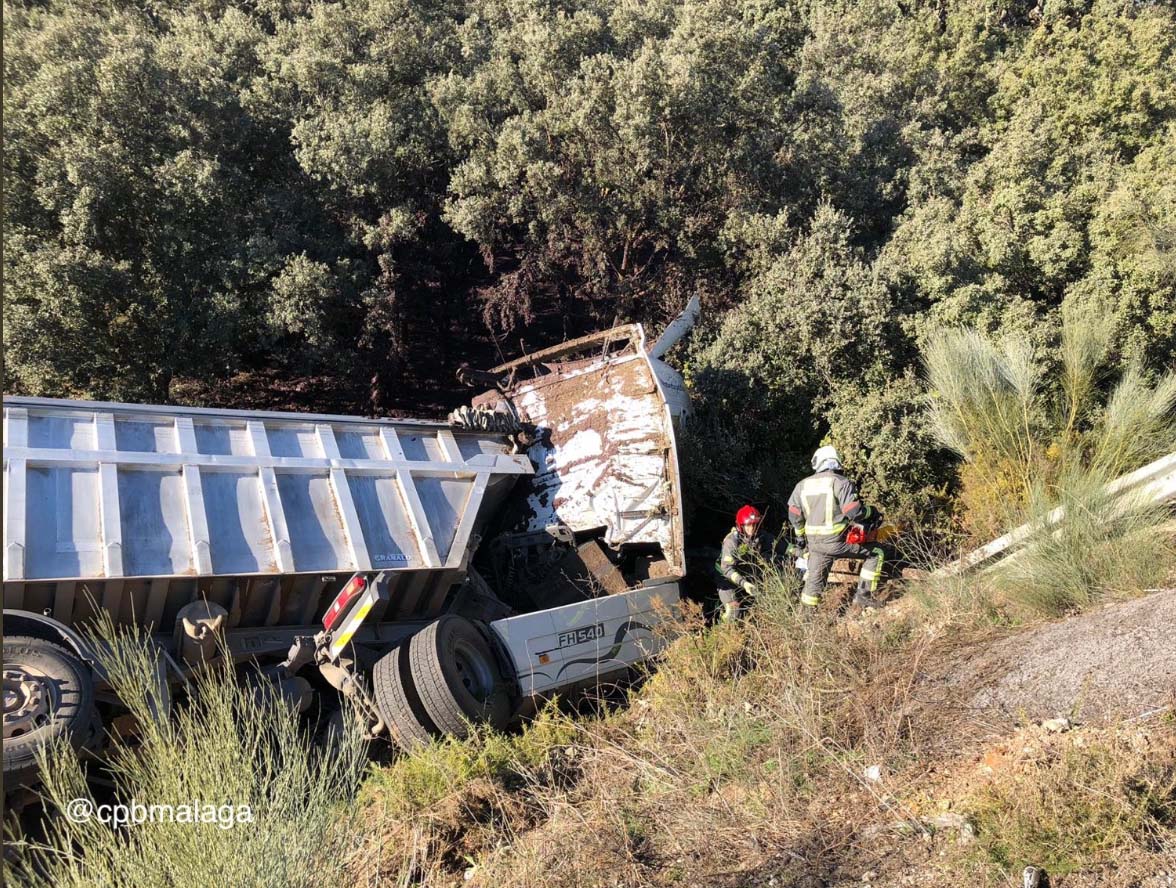 Momento en el que los bomberos de Ronda acceden al camión siniestrado.