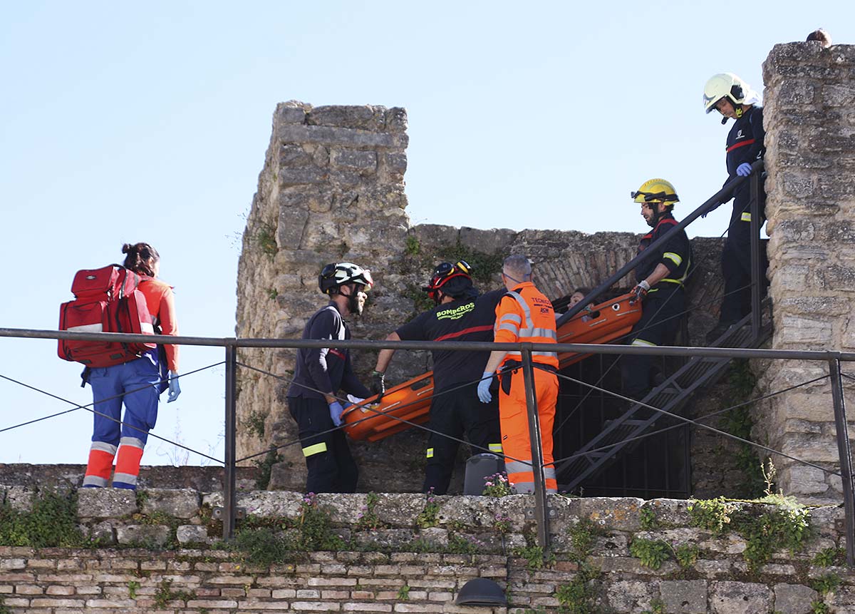 Momento en el que los bomberos bajan en camilla a la turista accidentada en una de las torres.