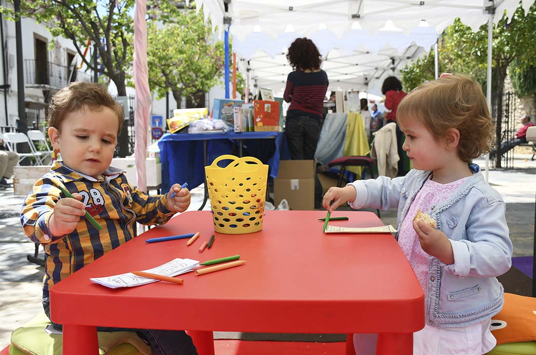 Dos pequeños del pueblo hacen dibujos en la celebración de la Feria del Libro.