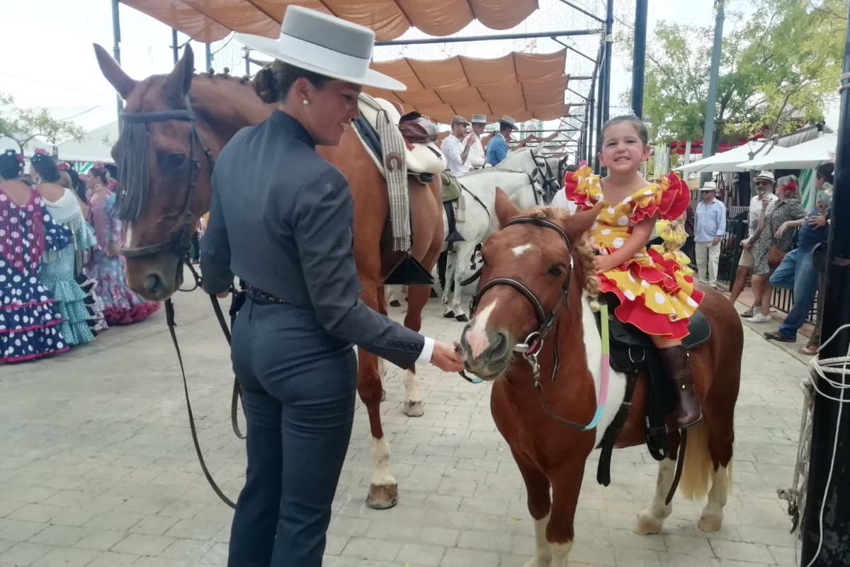 Una pequeña amazona posa a lomos de su pony.