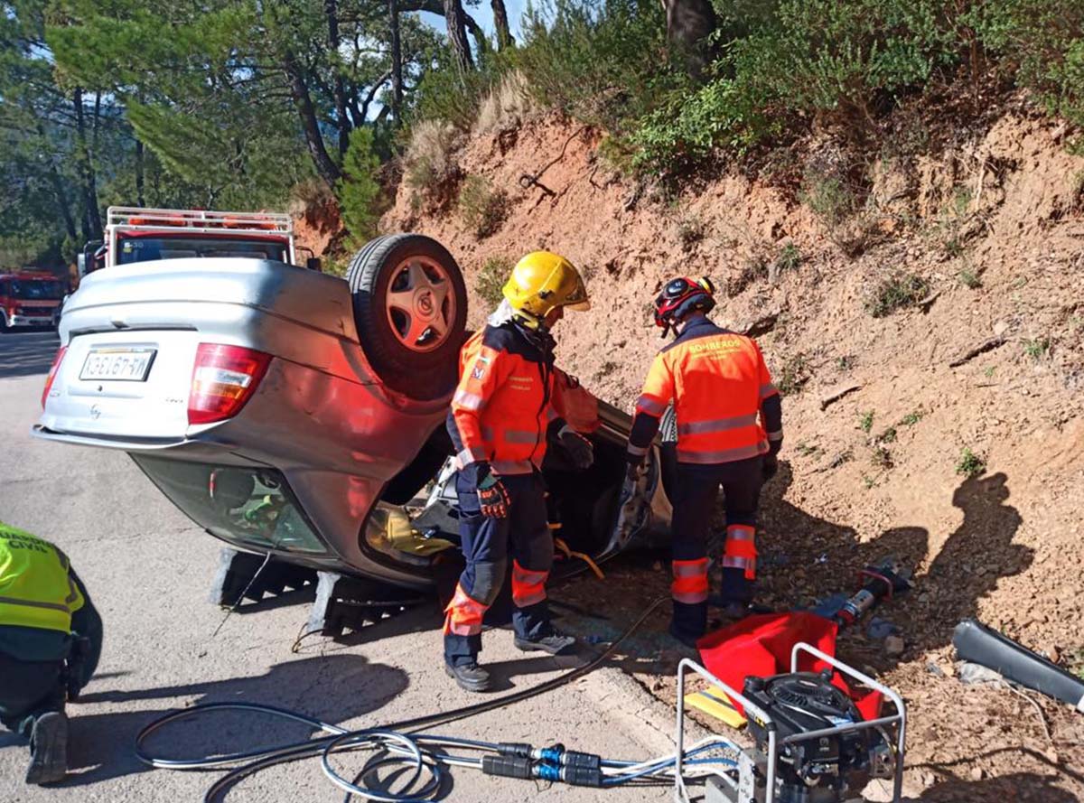 Momento en el que los bomberos rescatan a la mujer atrapada en su vehículo.