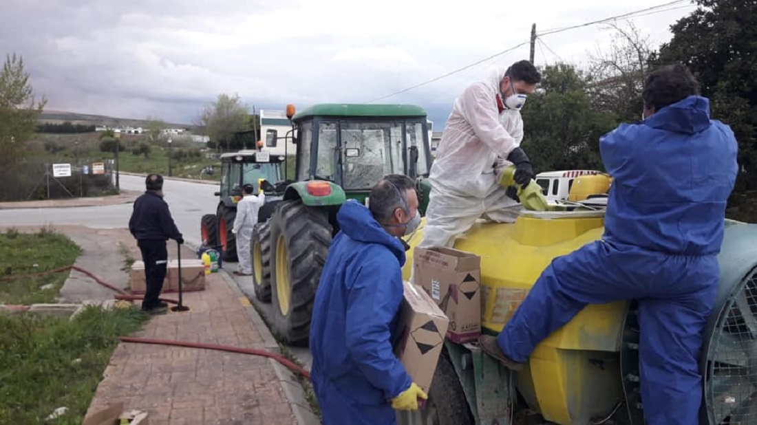 Agricultores y vecinos desinfectan las calles del pueblo con sus tractores.