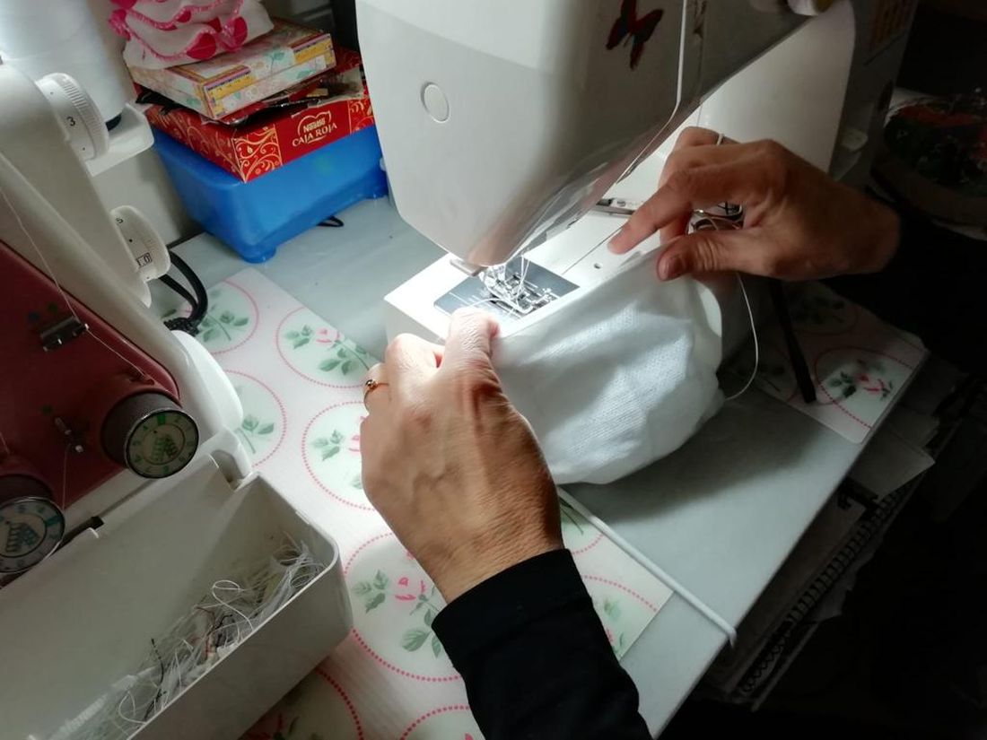 Participantes en los talleres realizan mascarillas para sanitarios en sus casas.