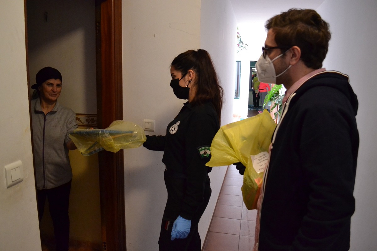 El concejal de Educación junto a una voluntaria de Protección Civil en el reparto de libros.