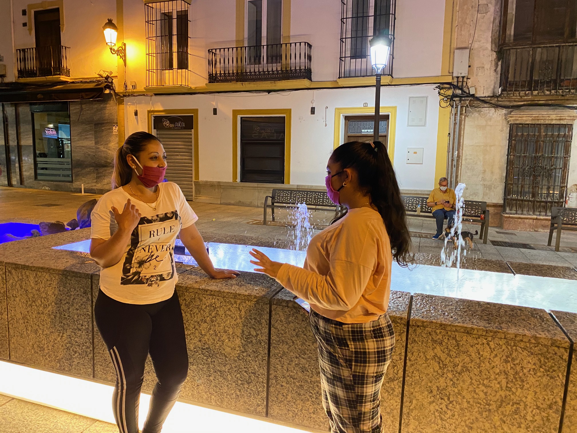 Dos chicas conversan en el centro de Ronda con las mascarillas puestas.
