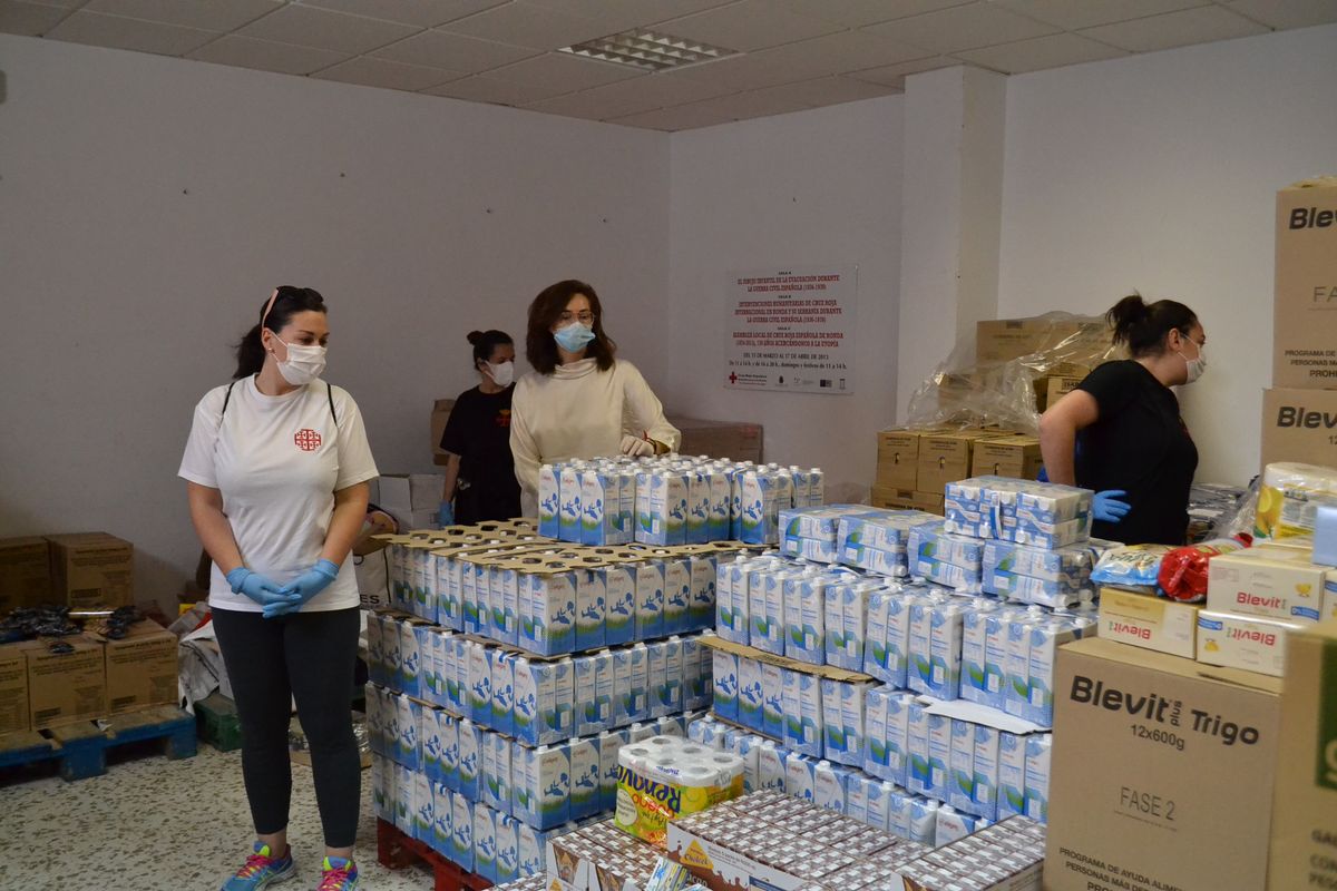 La concejal de Bienestar Social y voluntarias de la Hermandad del Santo Entierro preparando bolsas de alimentos.