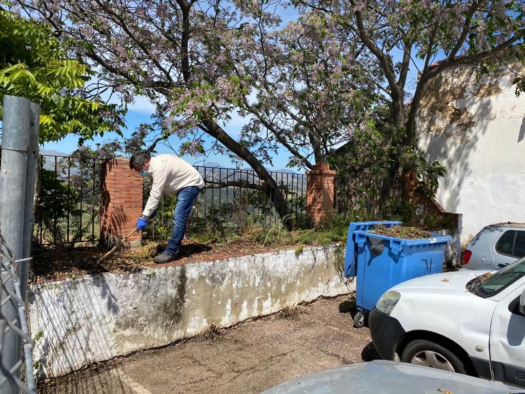 Uno de los operarios municipales retirando arbustos en el parking de El Castillo.