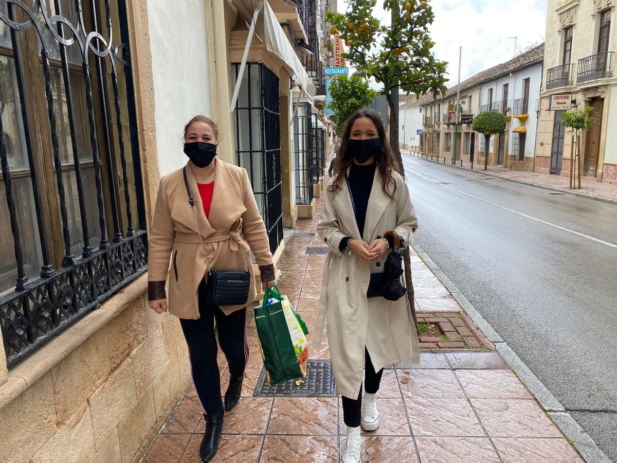 Dos mujeres con mascarillas realizando compras en el centro de la ciudad.