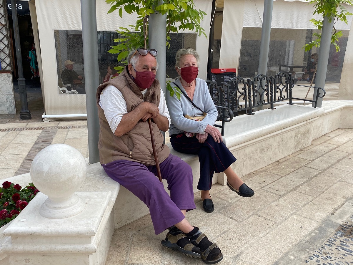 Dos personas mayores sentados en un banco de la Plaza del Socorro.