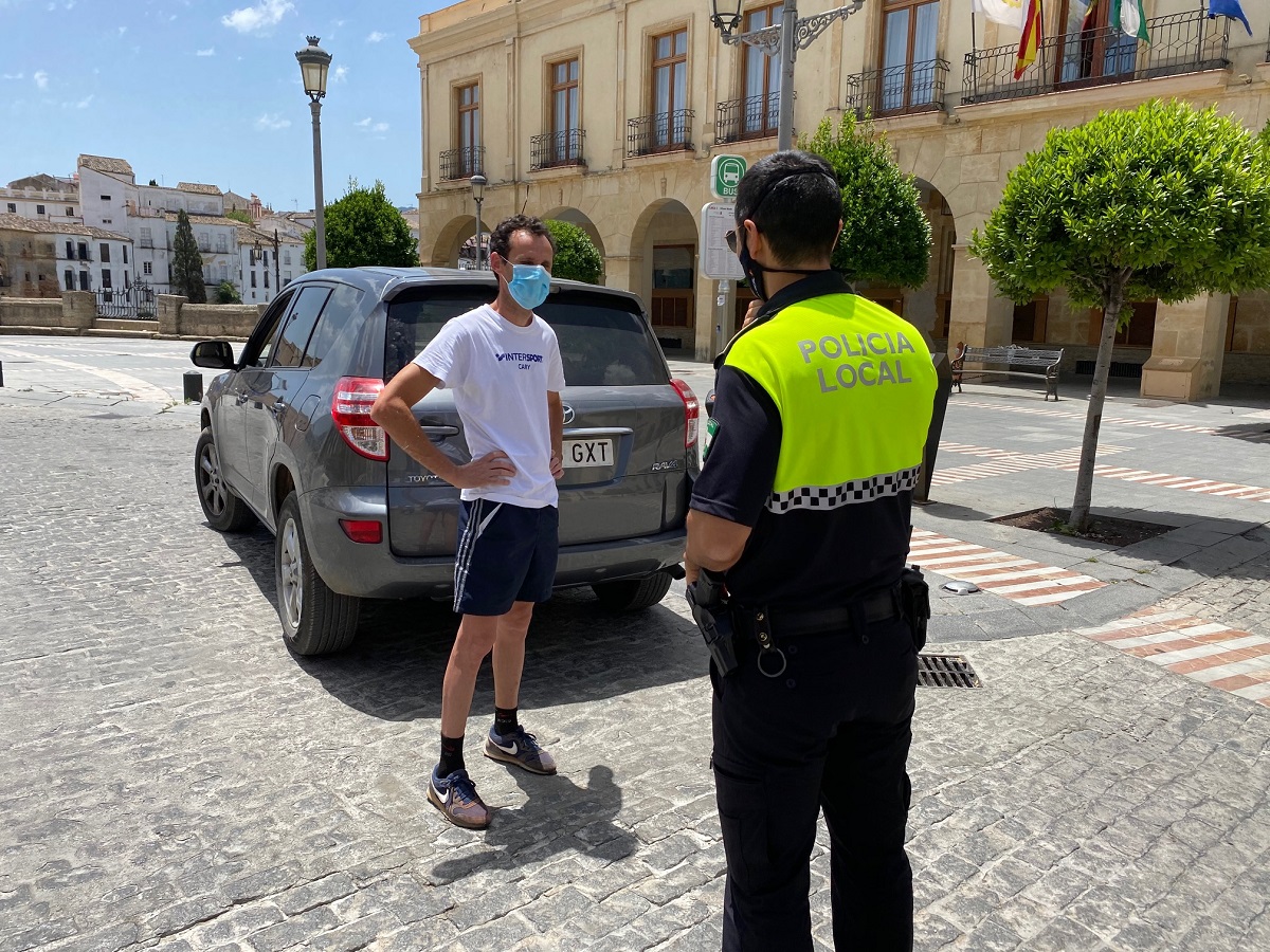 Un policía local y un ciudadano conversan en el centro de Ronda.