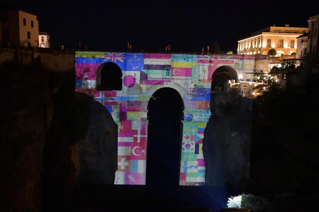 Imagen de las banderas de los países que visitan Ronda proyectada sobre el Puente Nuevo.