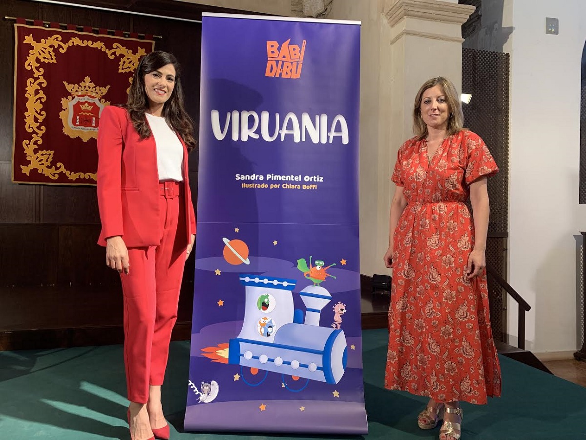 La autora del libro (a la izquierda del libro, junto a la concejal en la presentación de la obra.