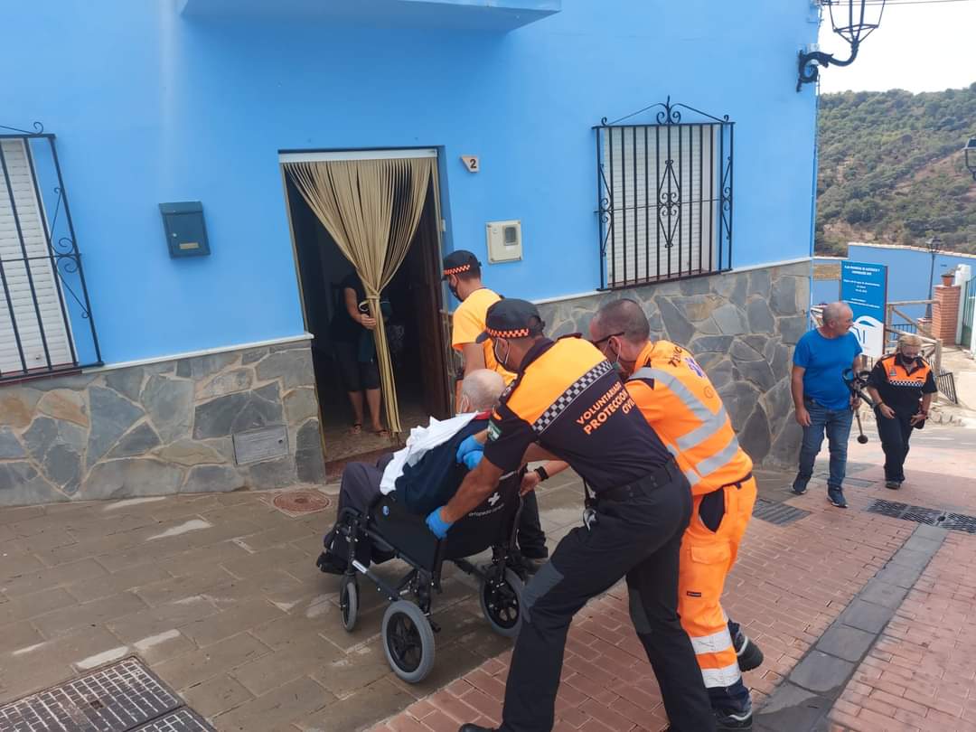 Miembros de Protección Civil retornando a su casa a un vecino de Júzcar, tras el incendio.
