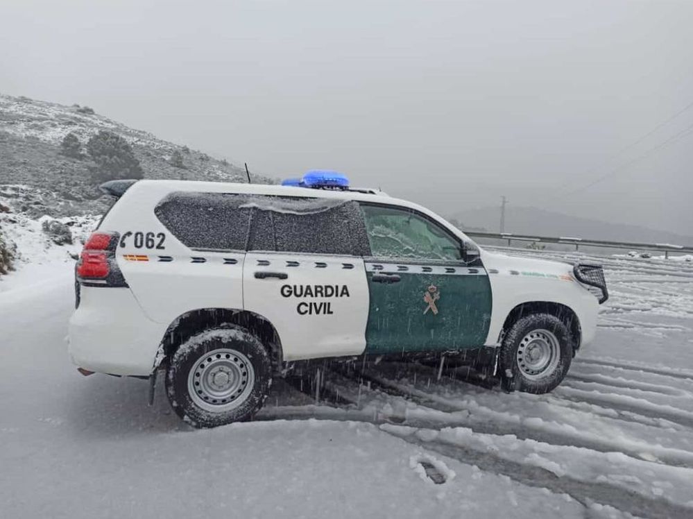 Un coche patrulla de la Guardia Civil en plena nevada.
