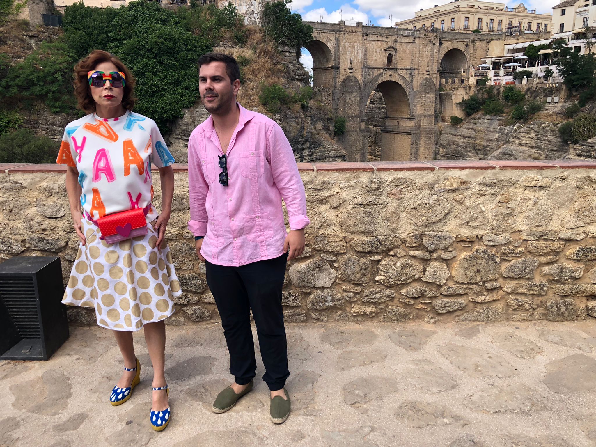 Agatha Ruiz de la Prada y el concejal de Turismo con el Puente Nuevo de fondo.