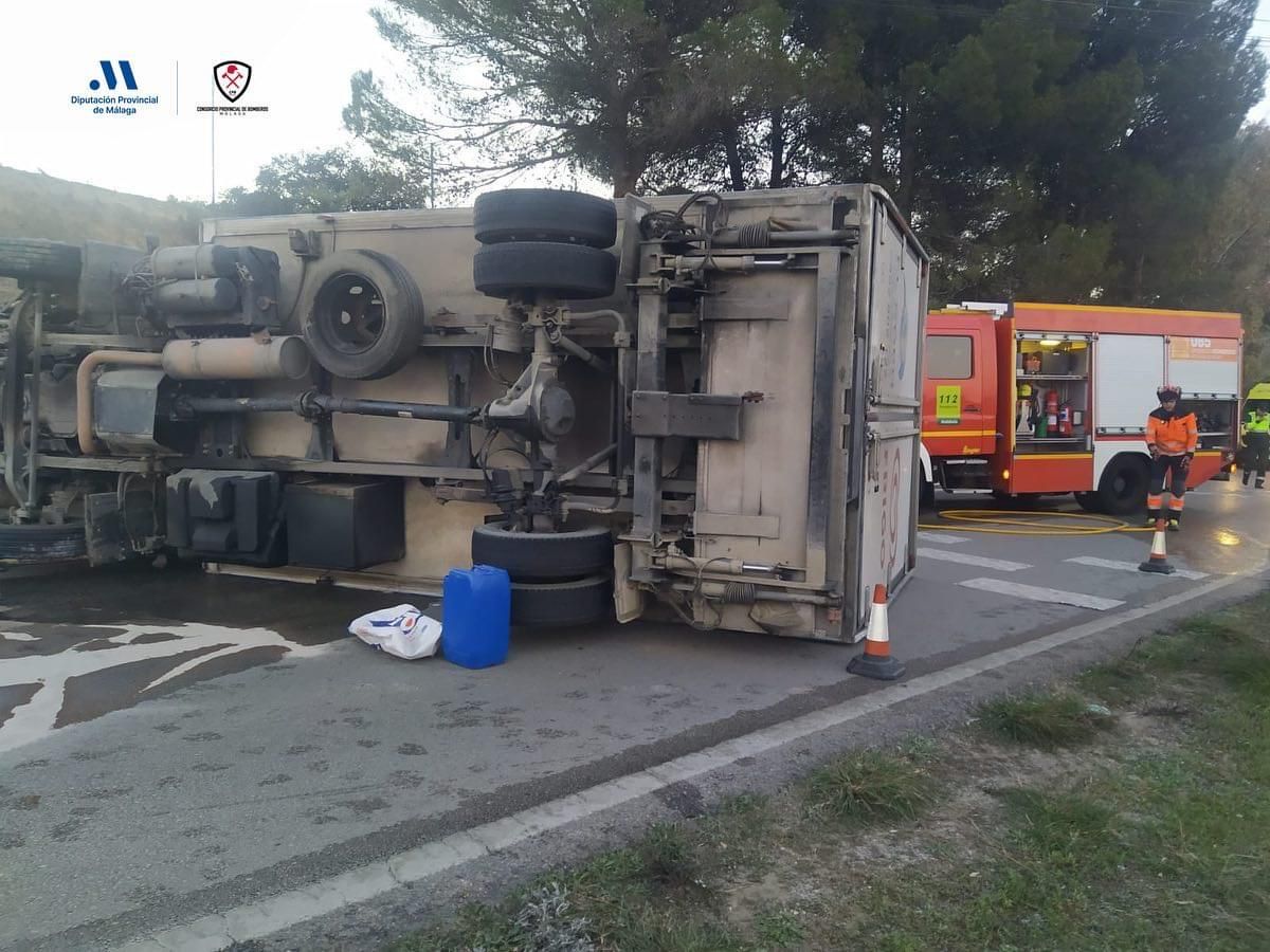 El conductor ha quedado atrapado en la cabina tras volcar el camión.