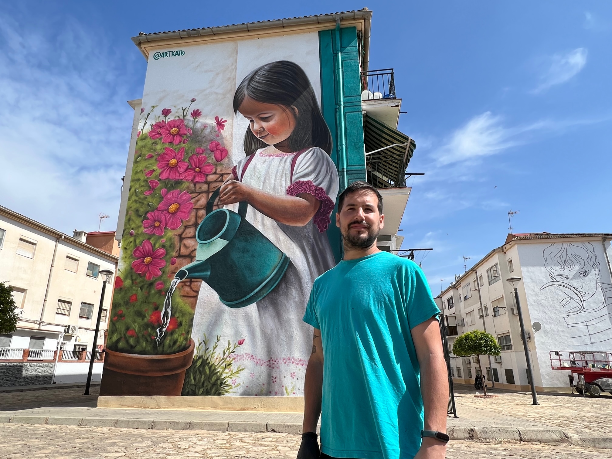 El artista grafitero Kato junto al primer mural que ya ha finalizado.